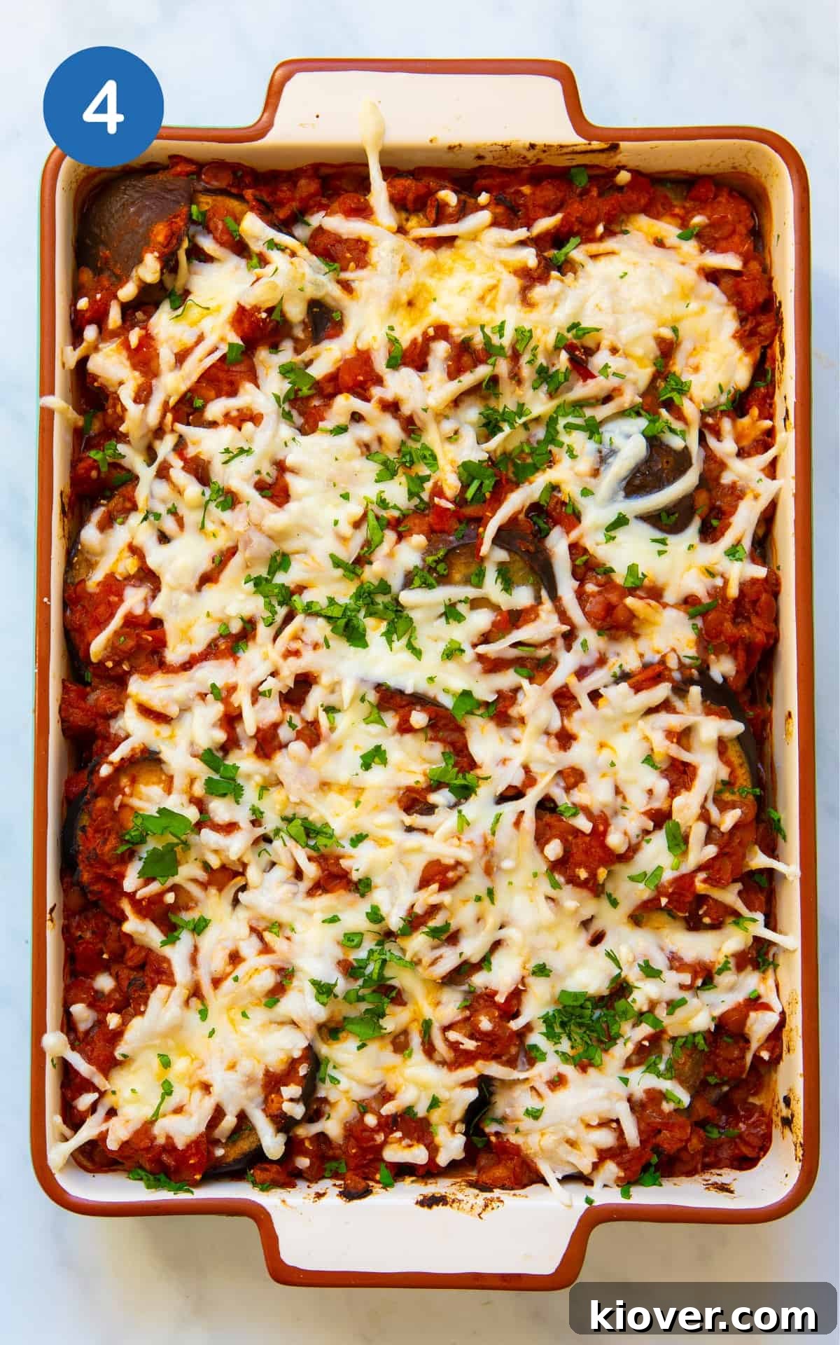 Creamy Baked Eggplant Casserole with Garlic and Herbs 7 Aubergine bake topped with cheese in a large baking dish with white background before being placed in the oven.