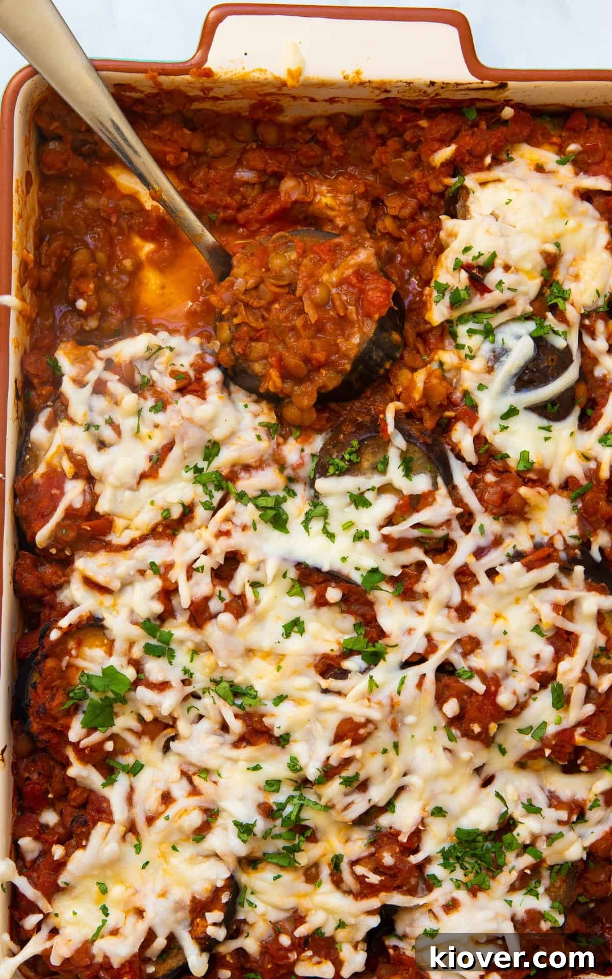 Creamy Baked Eggplant Casserole with Garlic and Herbs 8 Close up of aubergine bake in large backing dish being served with up with silver spoon.