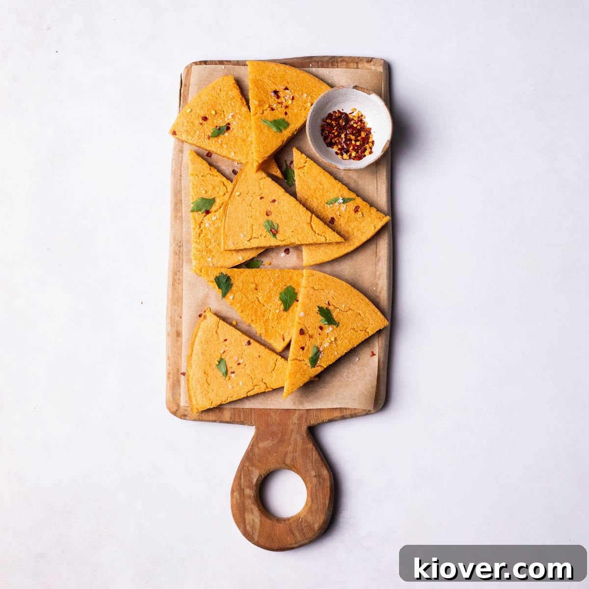Crispy Socca Chickpea Pancake Recipe for Beginners 2 Socca flatbread slices into triangles, served on a wooden board.
