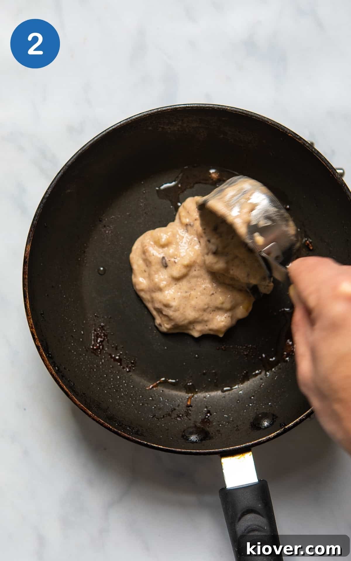 pouring the pancake batter into a non stick frying pan.