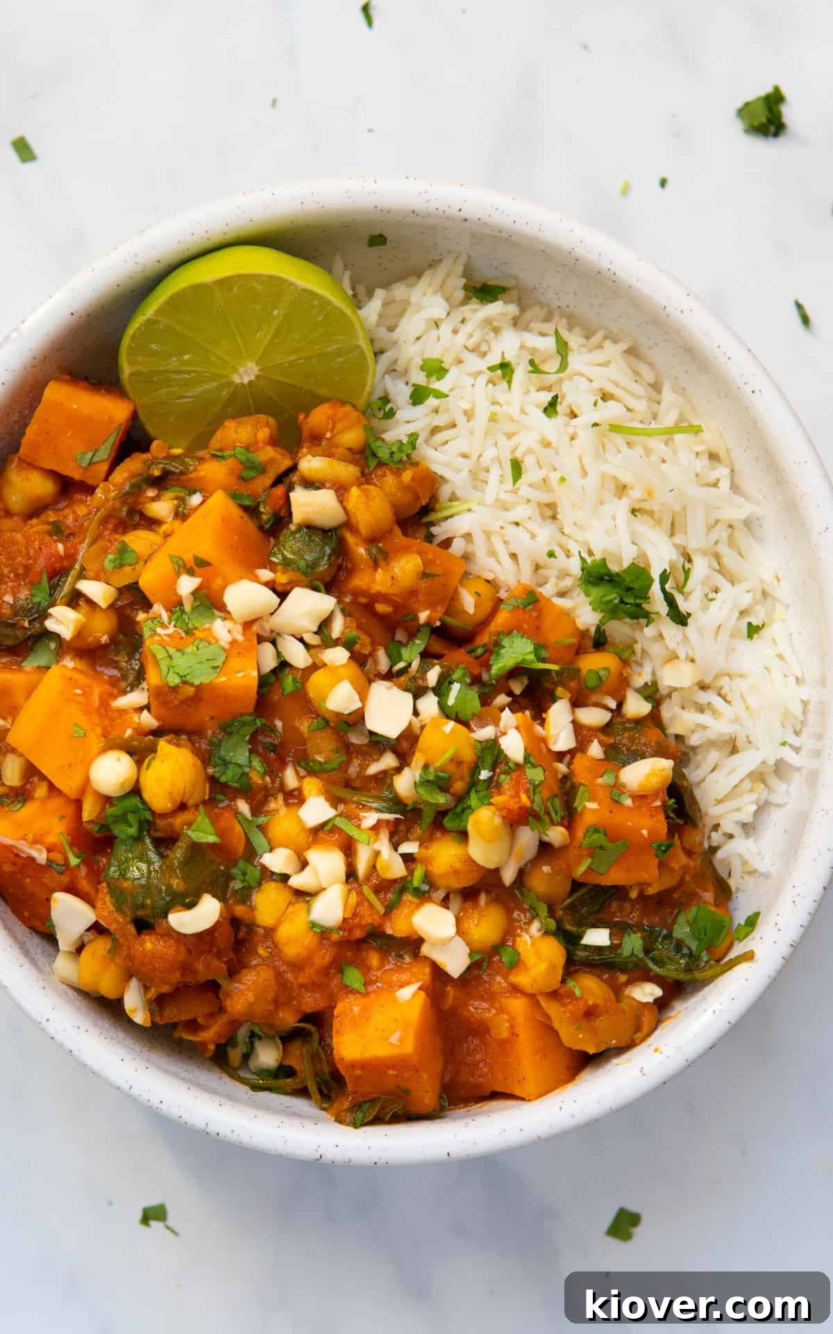 Creamy African Peanut Stew with Sweet Potatoes and Spinach 6 Peanut Stew served in a bowl with rice on the side.