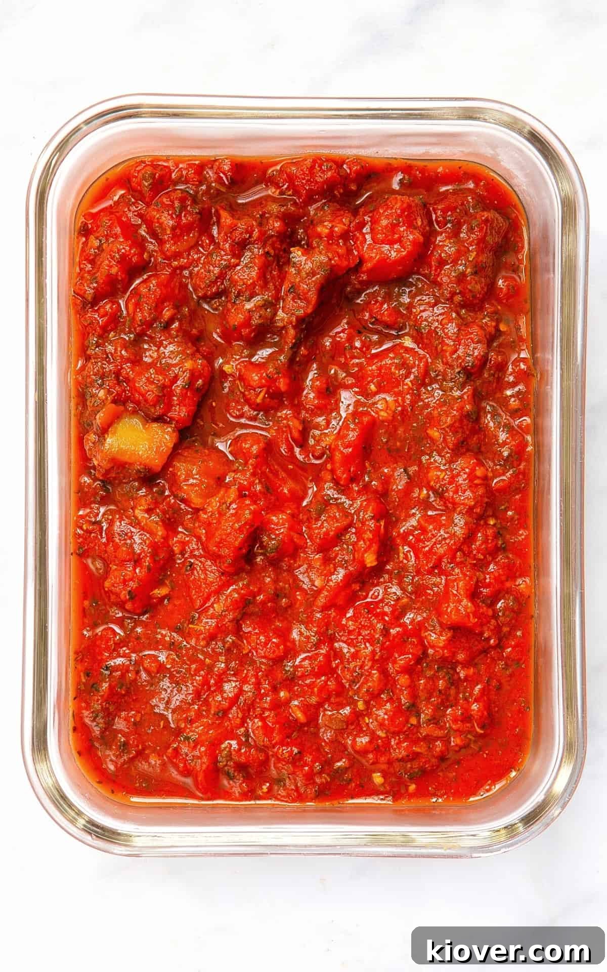 cooked pizza sauce in a glass jar ready to freeze.