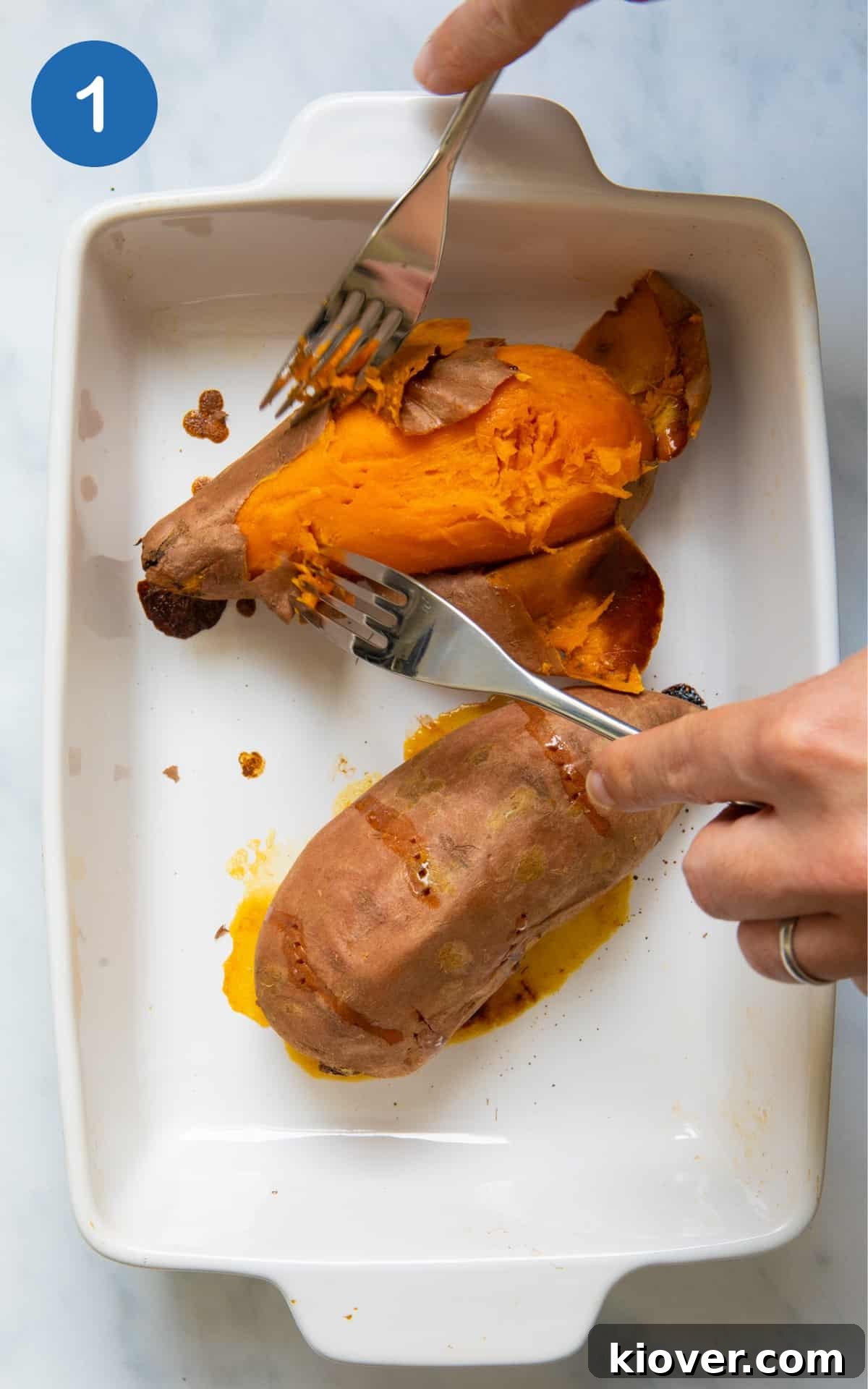 Sweet Potato Gnocchi Recipe: Light, Fluffy & Flavorful 4 2 sweet potatoes in a baking dish with skin being removed by fork. Baking dish is displayed on white background.