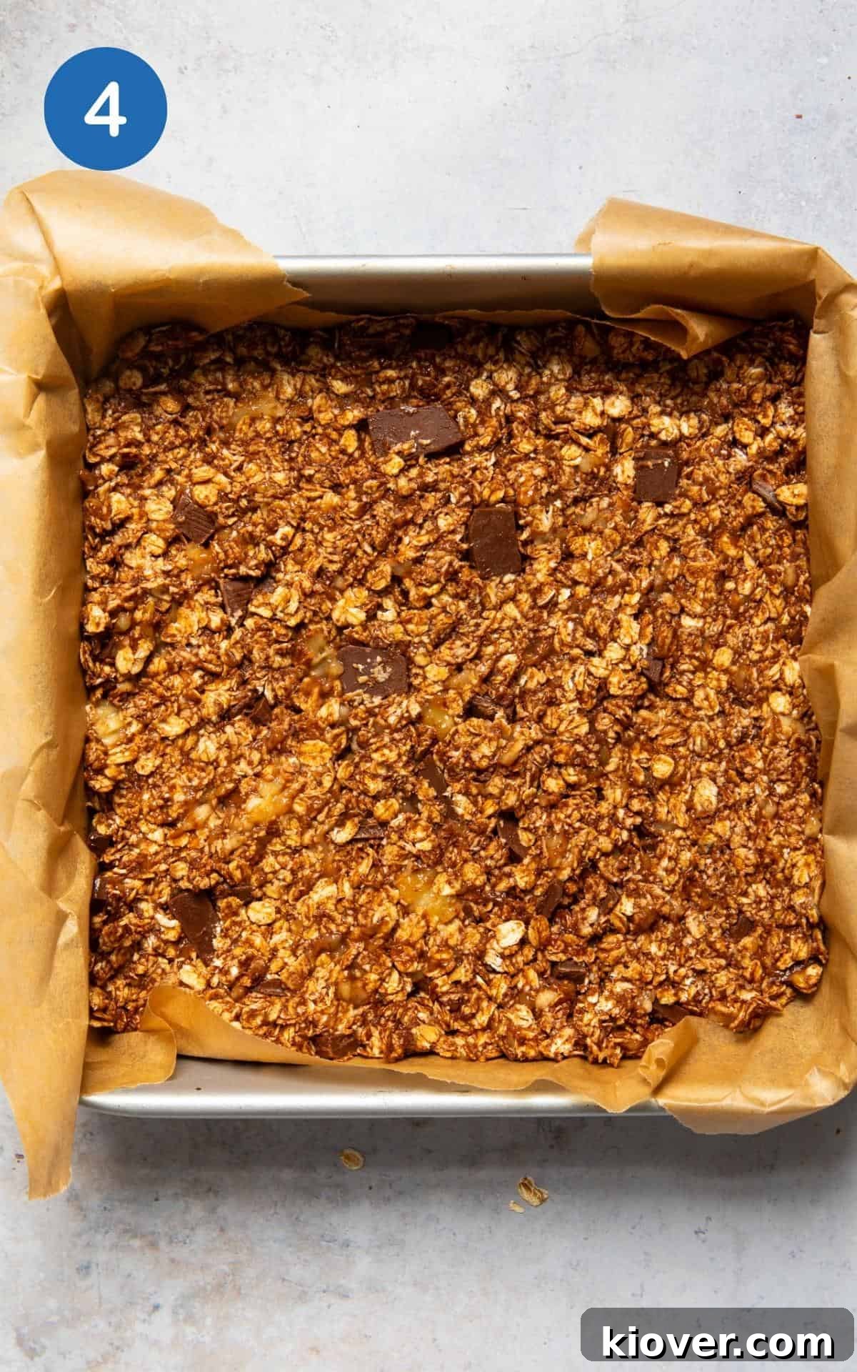 Chocolate flapjack mixture in lined baking tin before baking.
