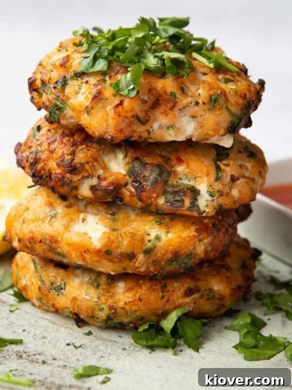Sweet Chilli Salmon Fishcakes stacked on top of each other, topped with coriander