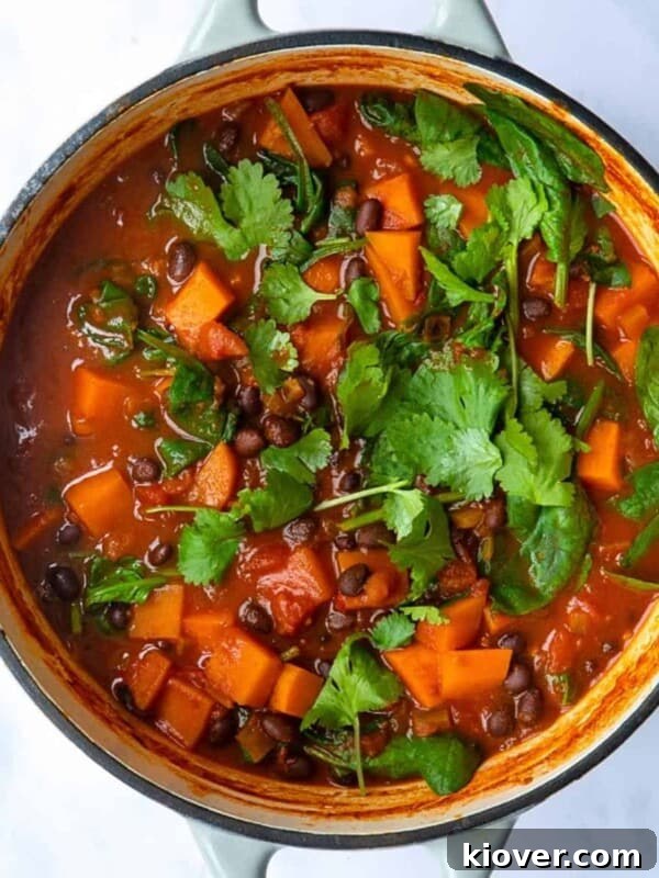 Sweet Potato and Black Bean Stew served in a large pot topped with coriander.
