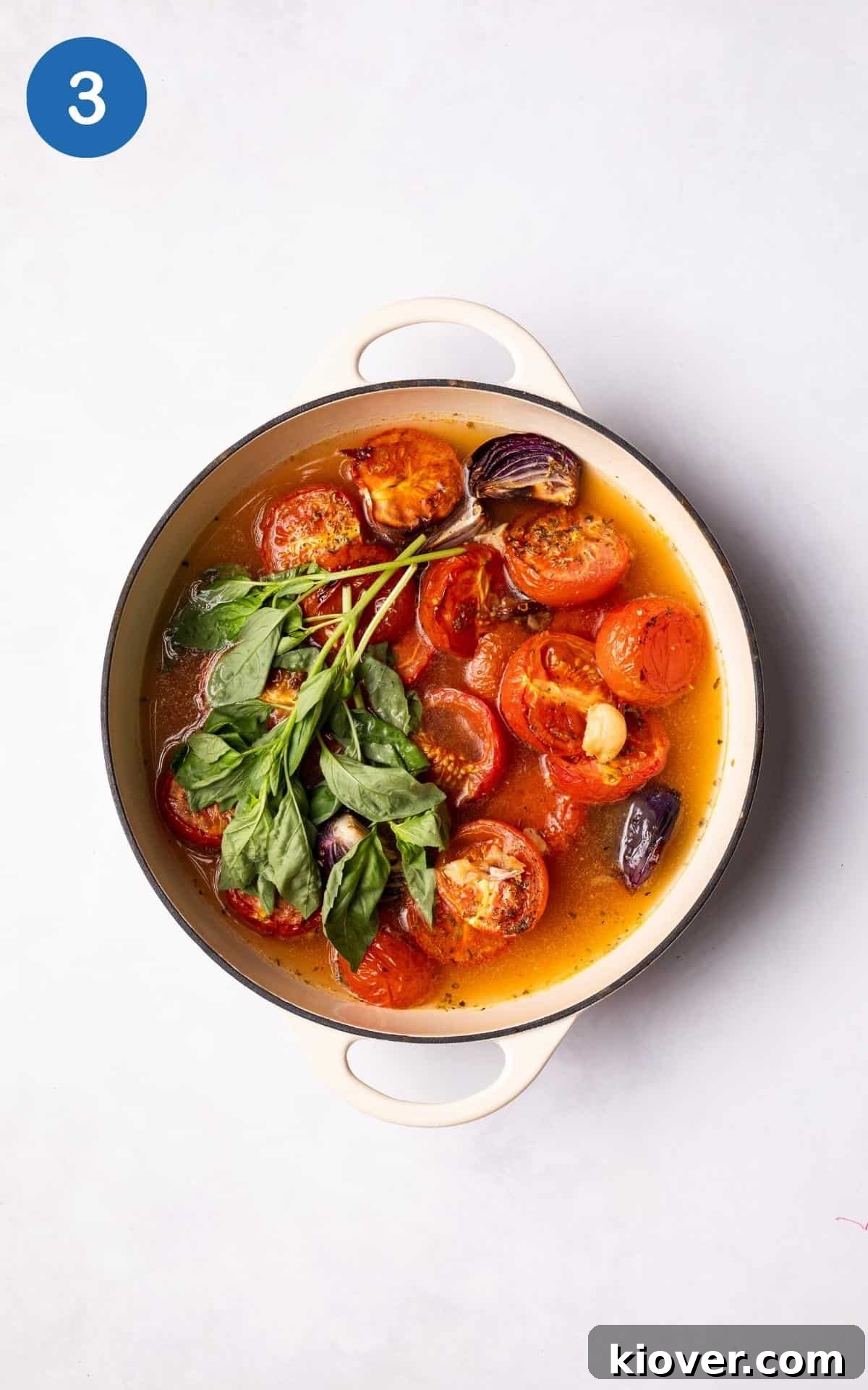 Tomatoes, basil and vegetable stock in a large pot.