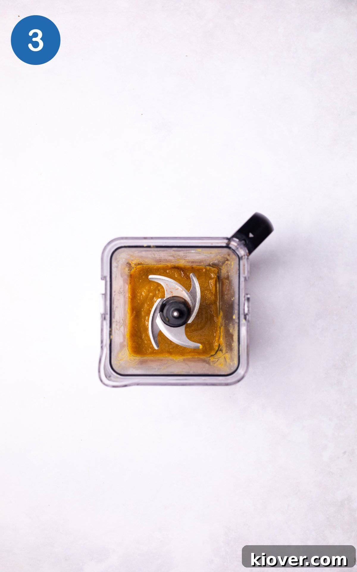 Pumpkin in a blender with maple syrup and cinnamon.