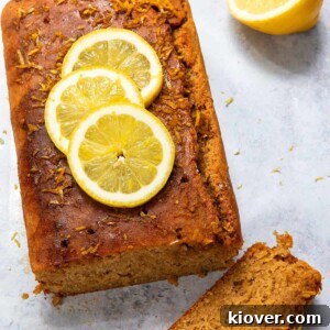 Vegan Lemon Drizzle Cake Recipe — Light Citrus Loaf 11 Lemon Drizzle cake cut into slices topped with fresh lemon slices.