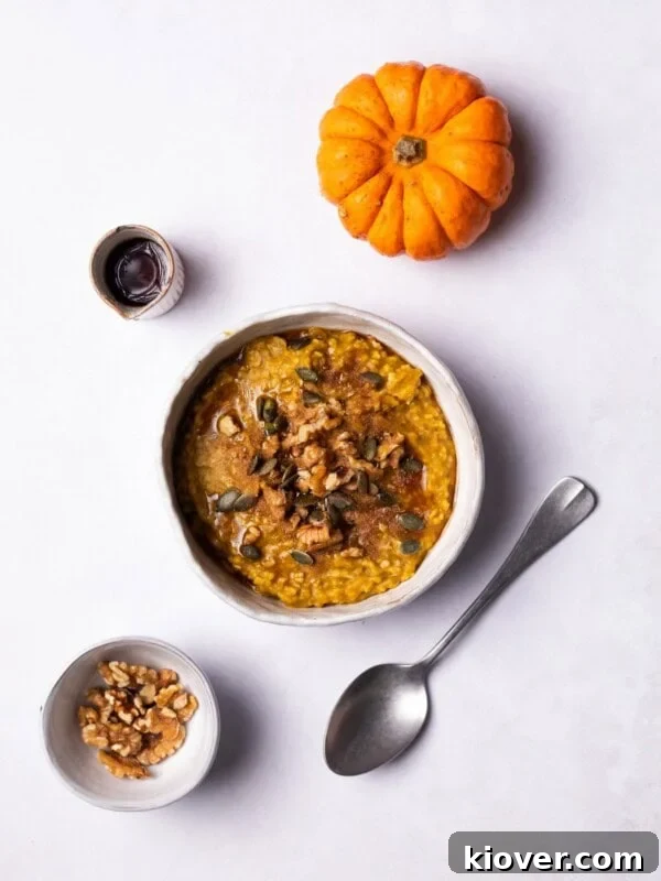 Pumpkin Oatmeal served in a bowl, topped with walnuts and pumpkin seeds.