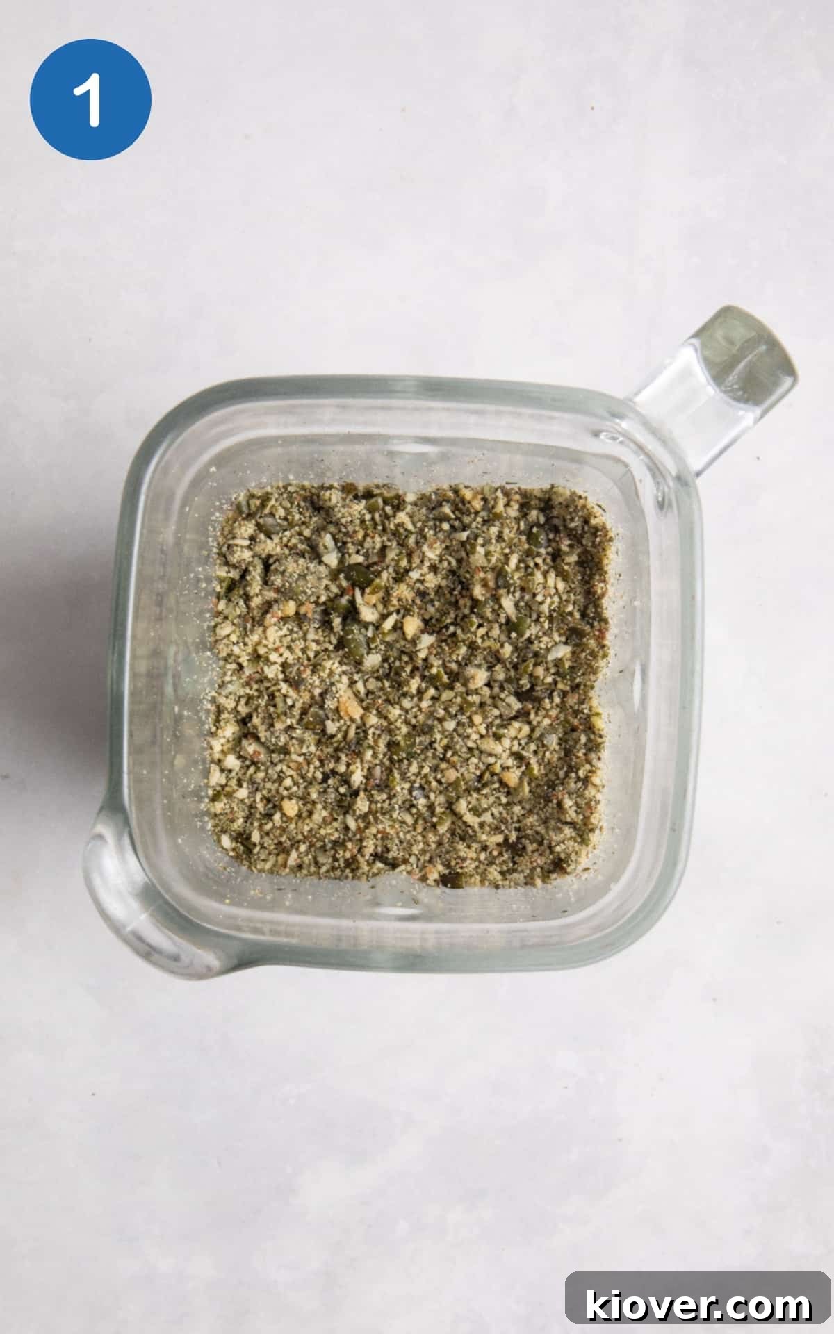 blended seeds in food processor on white surface.